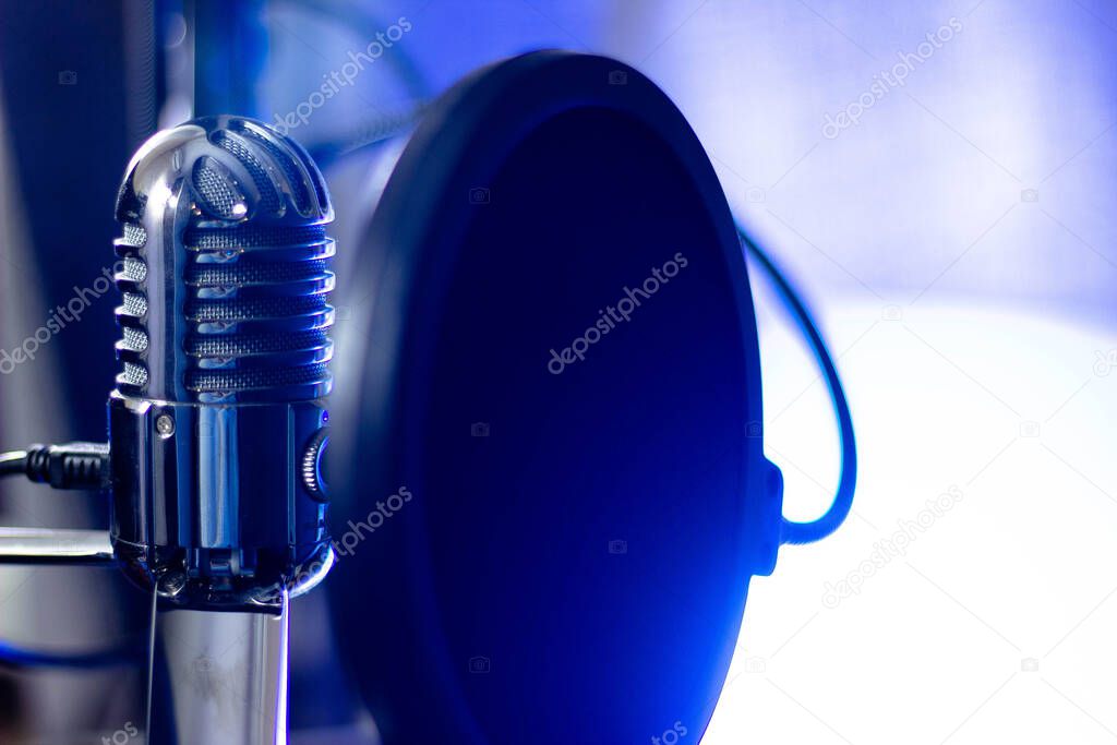 Microphone with pop filter on blue background