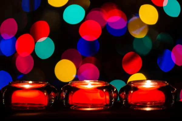 クリスマスライトに包まれる赤いクリスマスキャンドル — ストック写真