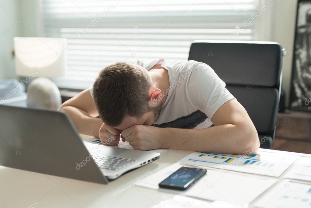 Tired business man sleeping at desk in office