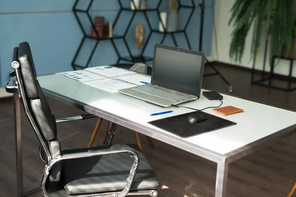 Moderno diseño interior de oficina con silla de oficina y escritorio frente a las ventanas. Lugar de trabajo con portátil —  Fotos de Stock