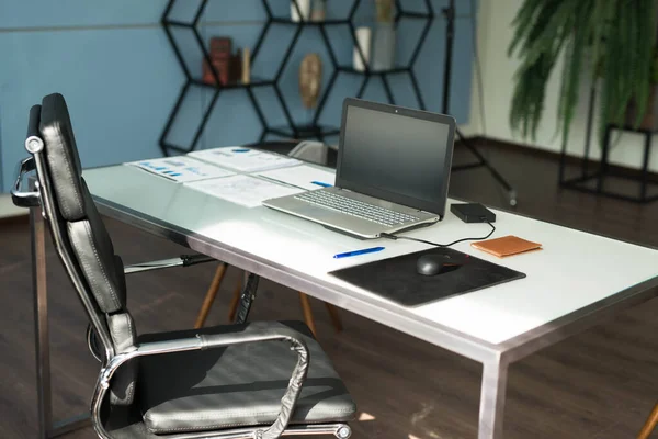 Modern office interior design with office chair and desk in front of windows. Workplace with laptop — Stock Photo, Image