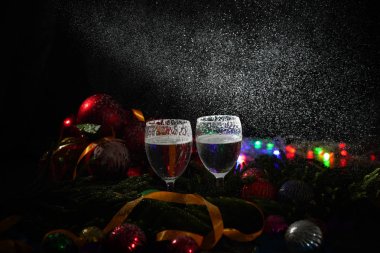 İki bardak şampanya ile arka planda bir Noel dekorasyonu         