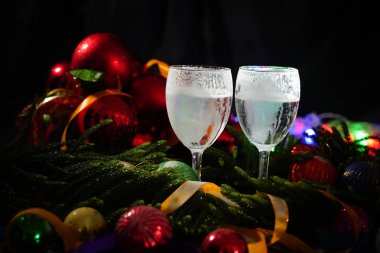 İki bardak şampanya ile arka planda bir Noel dekorasyonu         