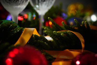 İki bardak şampanya ile arka planda bir Noel dekorasyonu         