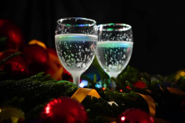 İki bardak şampanya ile arka planda bir Noel dekorasyonu         