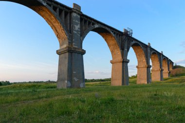 Eski Demiryolu Köprüsü yeşil alanda günbatımında kemerli.