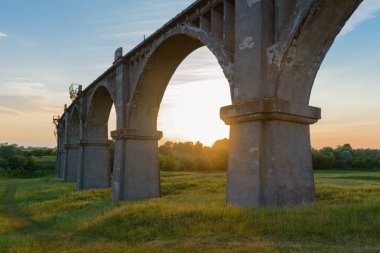 Eski Demiryolu Köprüsü yeşil alanda günbatımında kemerli.