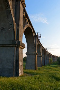 Eski Demiryolu Köprüsü yeşil alanda günbatımında kemerli.