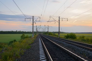 yaz akşamı ormanlar ve tarlalar arasında kutuplu demiryolu