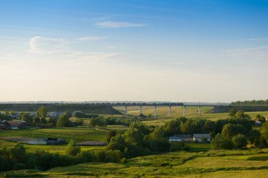 Yük treni köprüden köyün yanındaki uçurumun arasında hareket eder