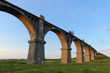 Eski Demiryolu Köprüsü yeşil alanda günbatımında kemerli.