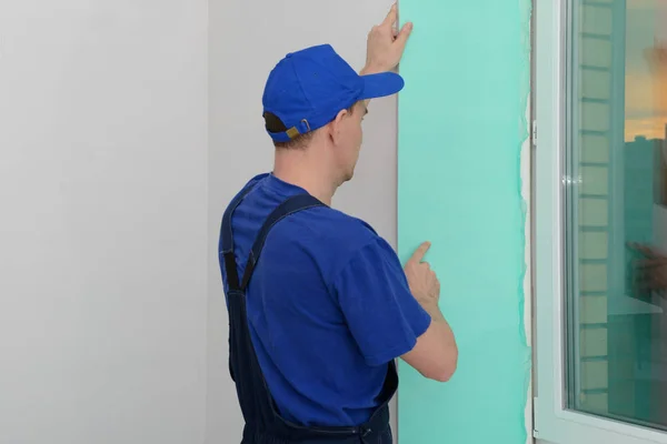 işçi mavi üniformalı bir Pvc sandviç panel Plastik pencere eteklerinde yükler.