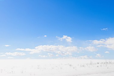 ıssız bir karlı alan ve açık mavi gökyüzü güneşli bir kış manzarası
