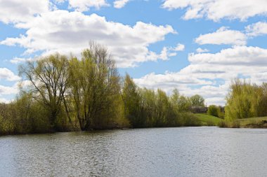 gölet ve eski bir ahşap yapı ağaçlarla, bahar yatay