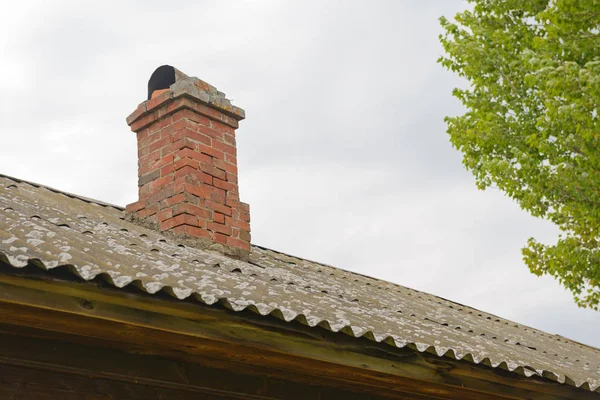 Old brick chimney on the roof of a house — Stock Photo, Image