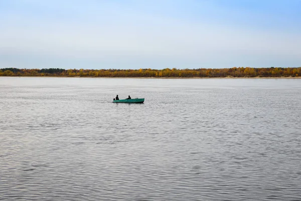 Bateau à rames avec deux hommes naviguant le long de la rivière le long de l'autum — Photo