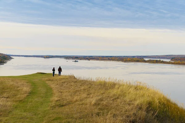 Un homme et une fille se tiennent sur une rive haute de la rivière et regardent dans — Photo