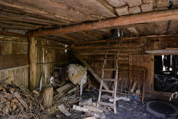 Старый заброшенный деревянный амбар с различным мусором — стоковое фото