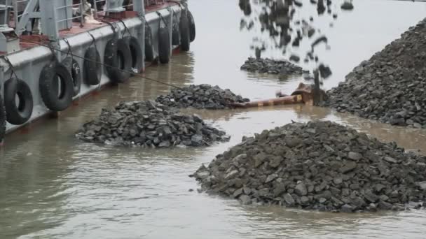 Zeitlupe. Ein Schlagkran auf einer schwimmenden Plattform arbeitet an der Befüllung und Verstärkung des Ufers des Baikalsees mit großen Steinen — Stockvideo