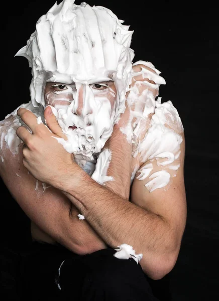 photo portrait of a strong guy smeared with shaving foam