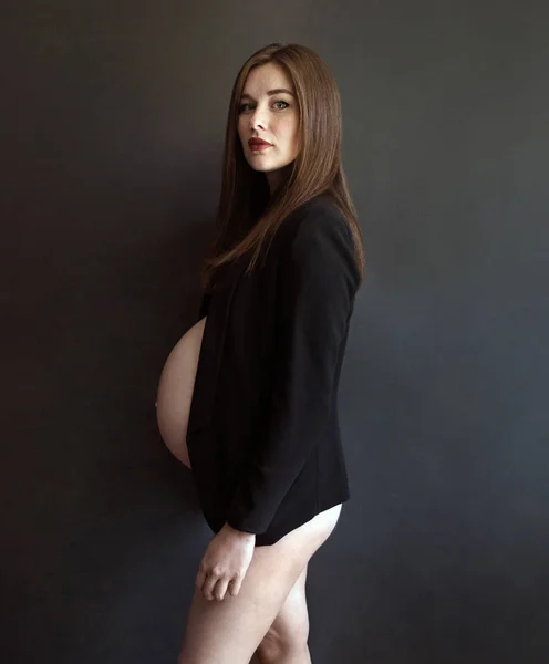 Foto Una Hermosa Embarazada Con Una Chaqueta Negra Sobre Fondo —  Fotos de Stock