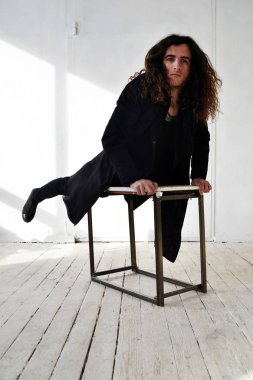 Fotoğraf adam siyah giysili uzun kıvırcık saçlı tablo beyaz arka plan tırmandı