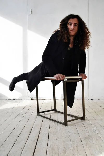 Fotoğraf adam siyah giysili uzun kıvırcık saçlı tablo beyaz arka plan tırmandı