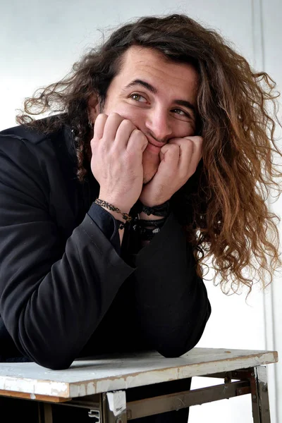 Fotoğraf portre etkileyici adam aktör ile siyah poz içinde uzun kıvırcık saçlı beyaz arka plan eller