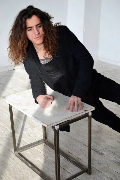 portre üzgün adam siyah giysili uzun kıvırcık saçlı masanın üzerine eğildi