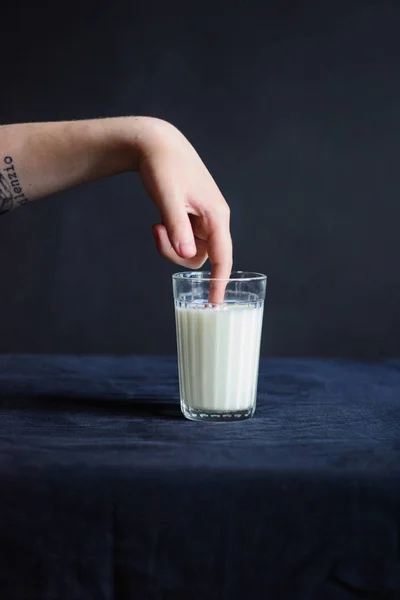 Foto Segelas Susu Taplak Meja Hitam Dan Tangan Menyentuh Susu — Stok Foto