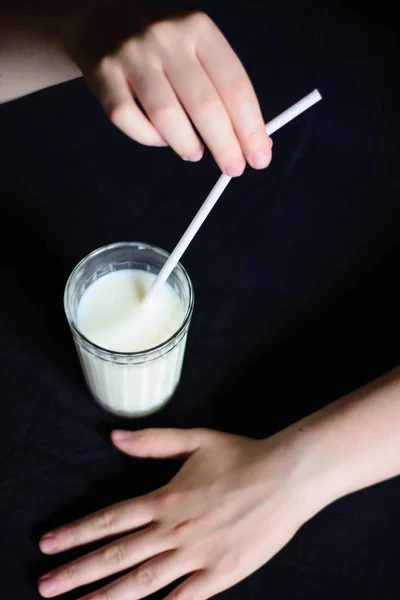 Foto Tangan Memegang Gelas Dengan Susu Dan Sedotan Pada Latar — Stok Foto