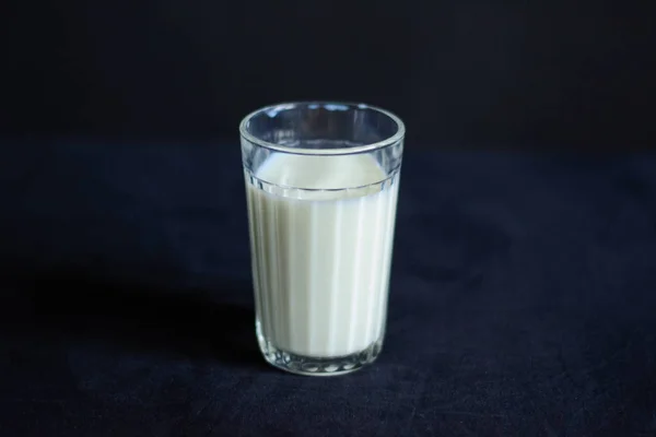 Foto Vaso Leche Está Parado Mantel Negro —  Fotos de Stock