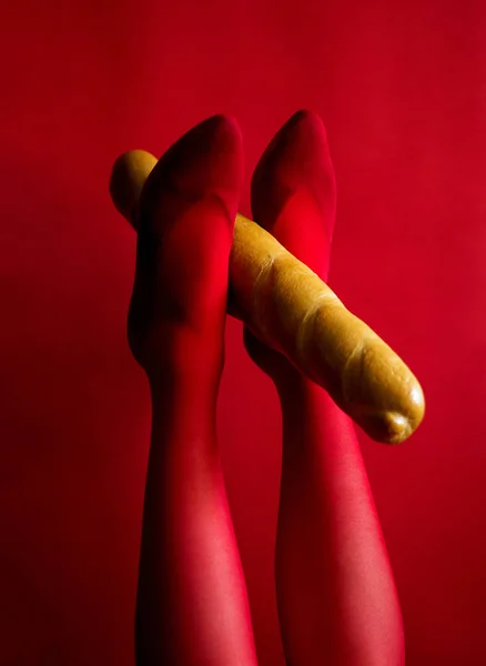 Kırmızı Taytlı Güzel Kadın Bacakları Ayaklarını Kaldırmış Bir Baget Tutuyor — Stok fotoğraf