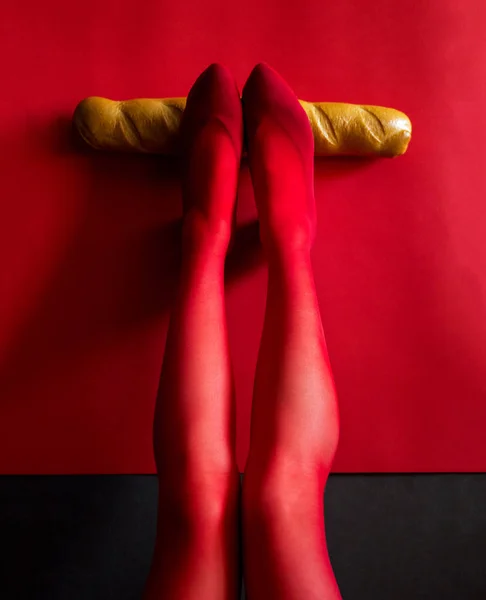 Foto Hermosas Piernas Femeninas Medias Rojas Sostienen Una Baguette Horizontalmente — Foto de Stock