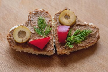 Kalp şeklinde kanepe ciğer ezmesi, zeytin, tatlı biber ve dereotla süslenmiş, evde pişiriliyor, kapat.