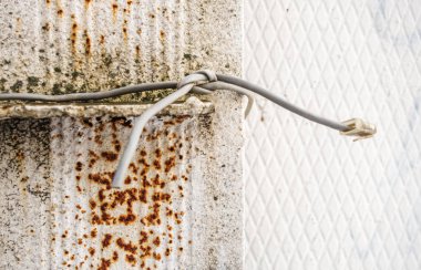 Kablo eski bir beton sütunun etrafına bağlanmış.