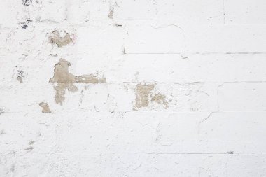 Beton bloklardan oluşan bir duvarın soyut arkaplanı şeffaf eski boyayla beyaza boyanmış.