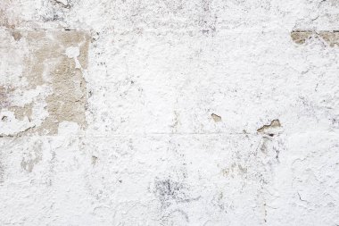 Beton bloklardan oluşan bir duvarın soyut arkaplanı şeffaf eski boyayla beyaza boyanmış.