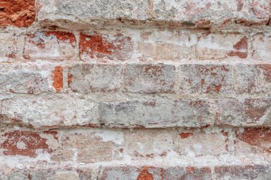 Soyulmuş alçı ve pembe boya kalıntıları olan eski bir duvarın soyut arkaplanı.