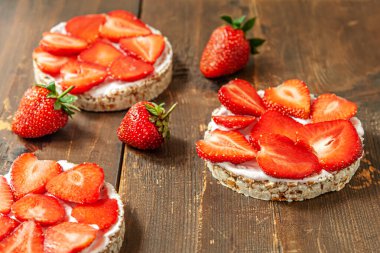 Yoğurtlu gevrek ve ahşap bir masada dilimlenmiş çilek.