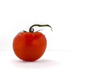 Minimalist, beyaz arkaplanda su damlalarında taze hamur domatesinin hayatı