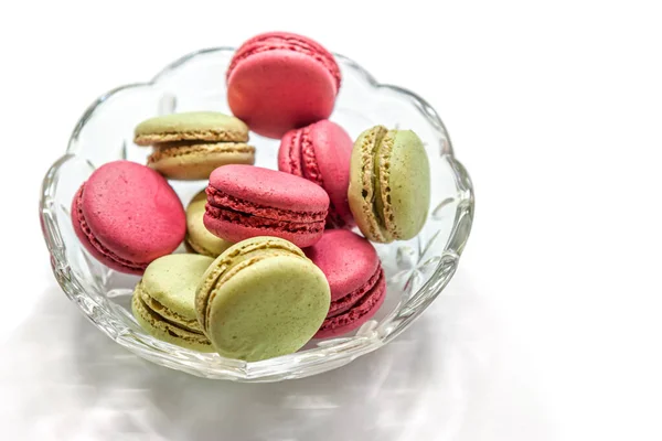 raspberry and pistachio macaroon cakes in a glass bowl isolated on white