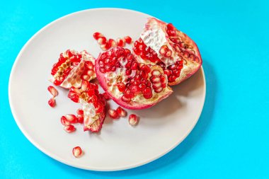 sulu olgun nar mavi bir yüzey üzerinde bir tabakta