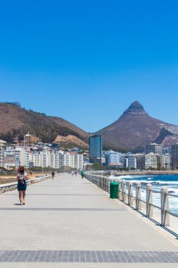 Dağlar, oteller ve derin mavi sular Sea Point 'te dalgalar, Cape Town Güney Afrika' da sahil gezintisi.