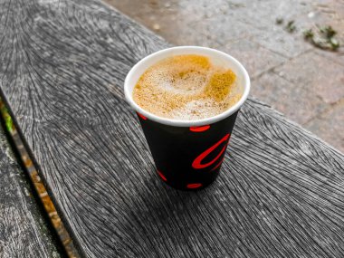 Red paper cup with coffee to go on wooden ground. Leherheide, Bremerhaven. clipart
