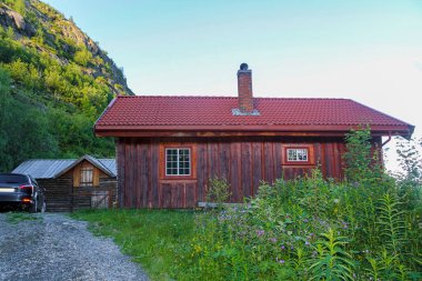Hemsedal, Norveç 'te park etmiş koyu mavi bir arabası olan eski kahverengi ahşap kulübe..