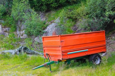 Hemsedal, Norveç 'te bir çayırda kırmızı traktör römorku..