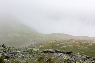 Hemsedal Norveç 'teki Veslehdn Veslehorn dağında sis, bulutlar, kayalar ve uçurumlar.