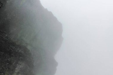 Hemsedal Norveç 'teki Veslehdn Veslehorn dağında sis, bulutlar, kayalar ve uçurumlar.