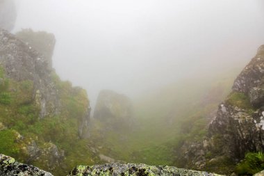Hemsedal Norveç 'teki Veslehdn Veslehorn dağında sis, bulutlar, kayalar ve uçurumlar.